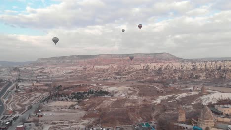 globos aerostáticos vuelan sobre el valle de goreme en capadocia, turquía - amplia antena ascendente