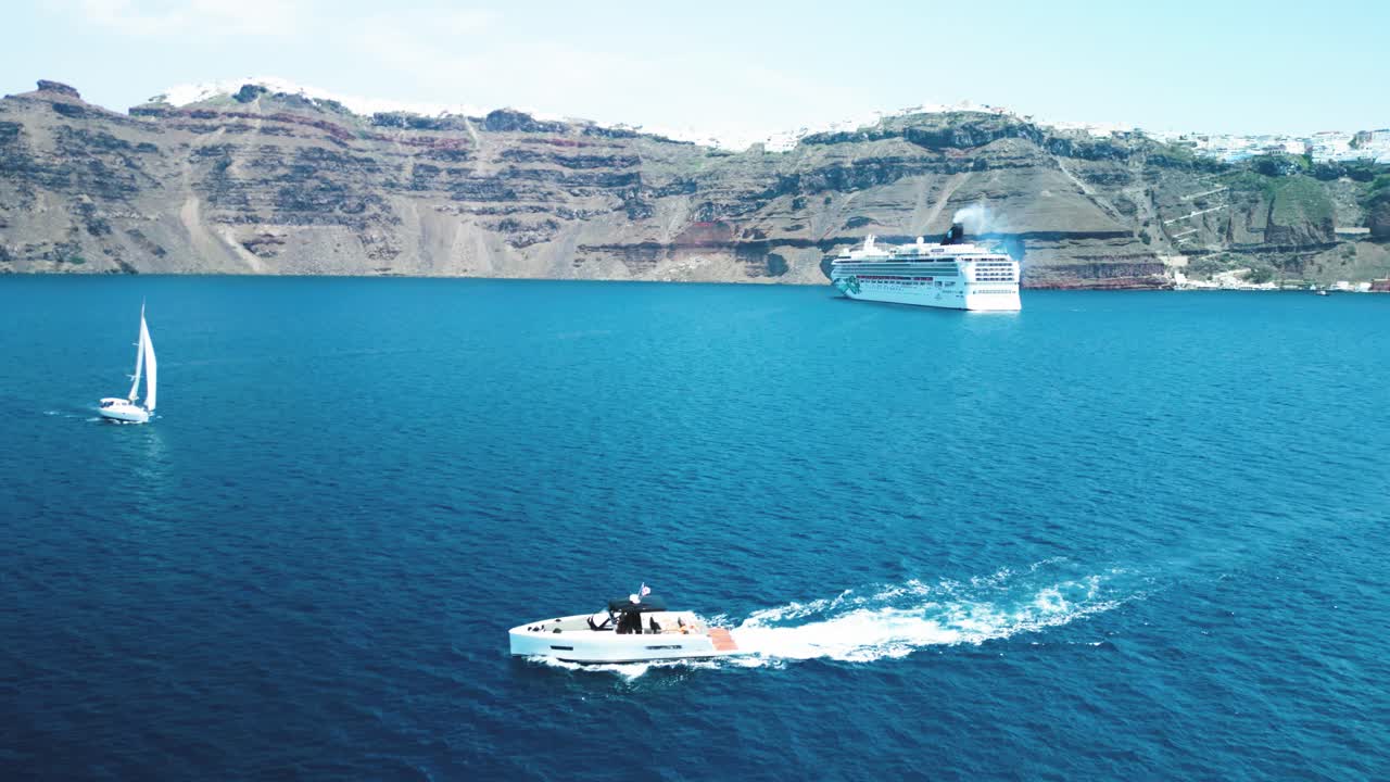 barco no tripulado aéreo a través de las aguas azules en santorini