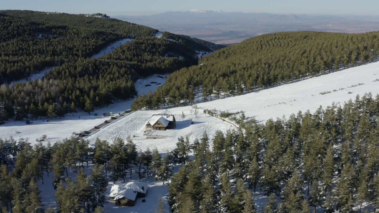 cabaña de esquí desierta y pendiente en medio de un espectacular verde y blanco de nieve y pinos