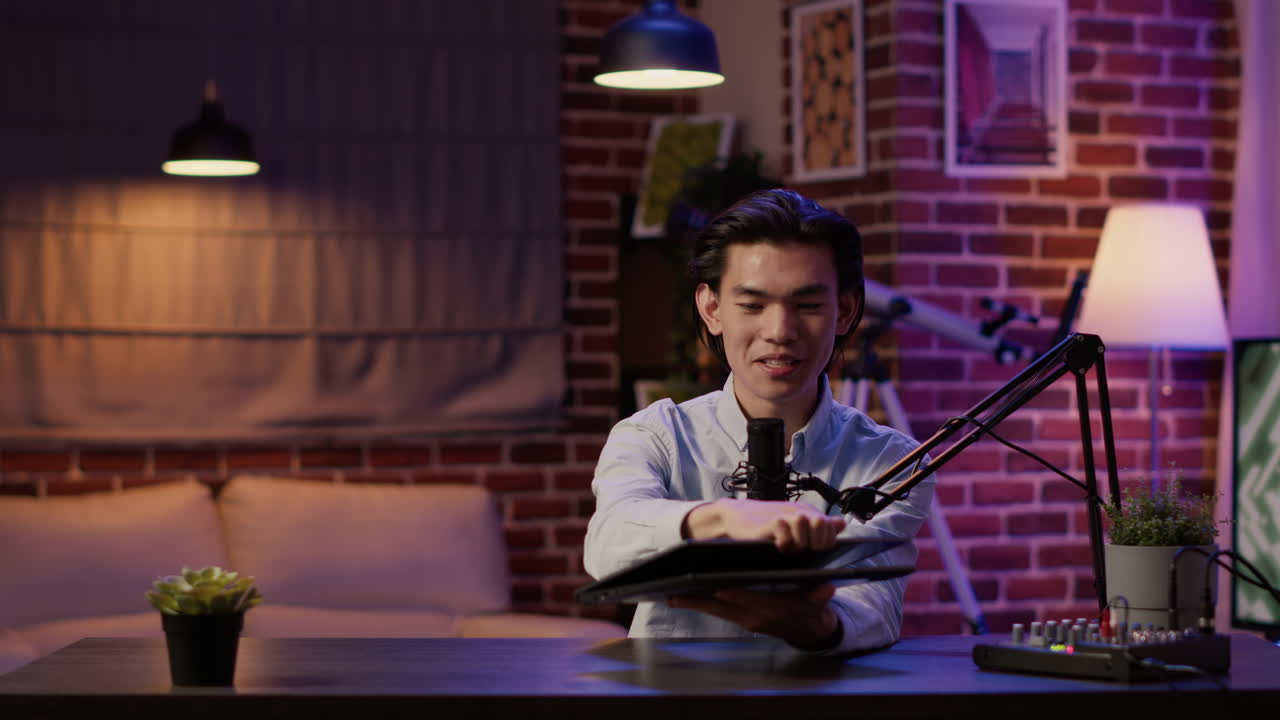 Un uomo mostra un portatile in uno studio