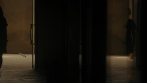 silhouette of a college girl in uniform walking alone in dark school hallway