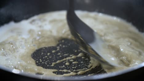 Gelbe-Thai-Currypaste-In-Einer-Heißen-Pfanne-In-Weißer-Kokosmilch-Aufkochen-Und-Auflösen