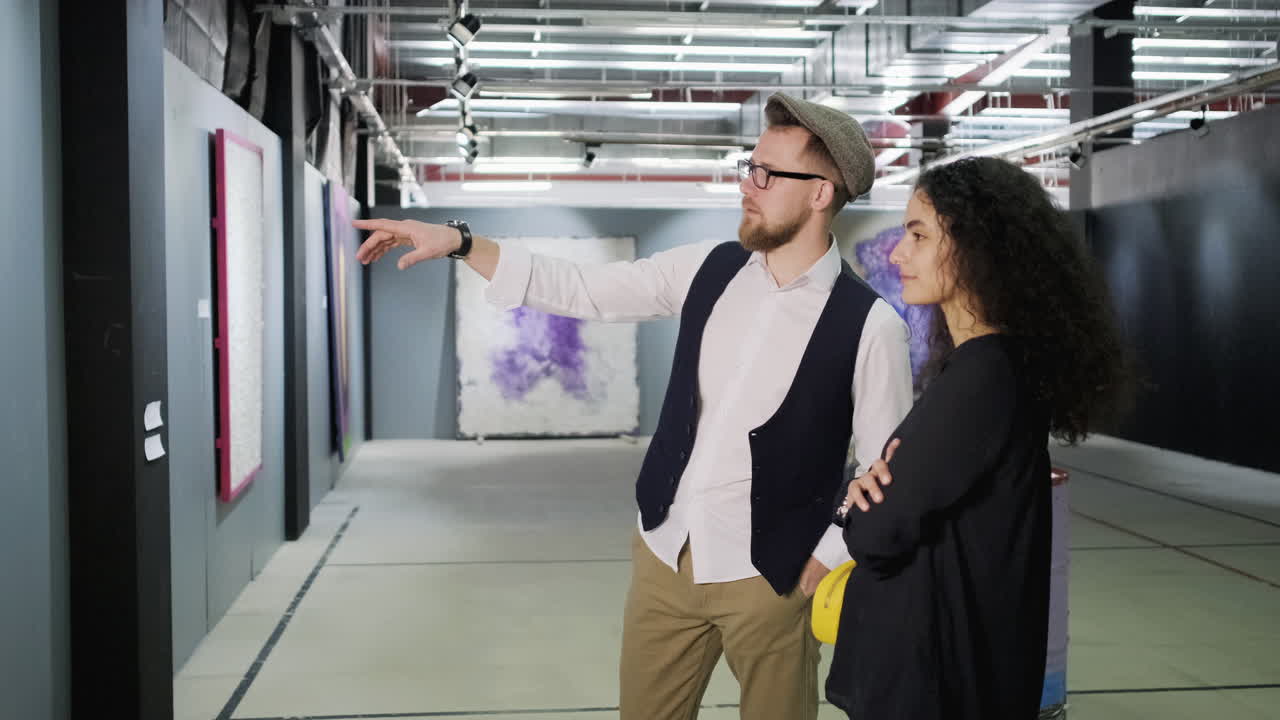 한 부부가 산업 갤러리에서 추상 미술을 보고 있다