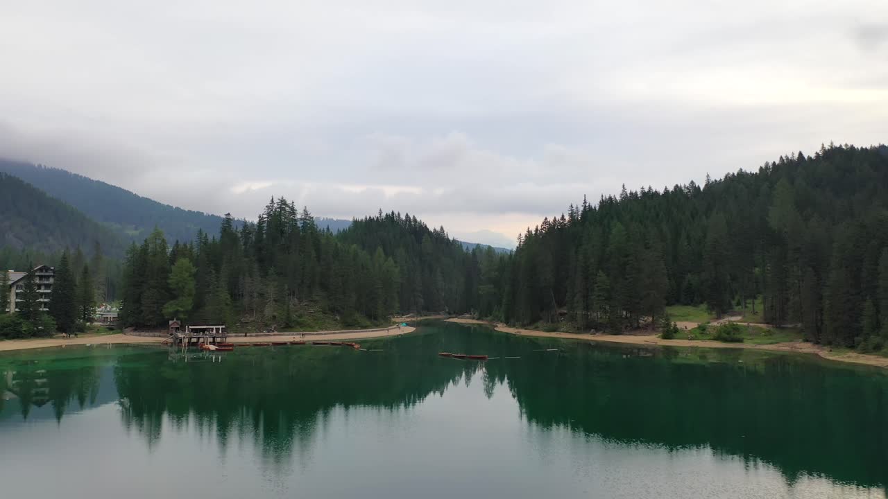 Rowboats floating in Lago di Braies lake, backwards aerial