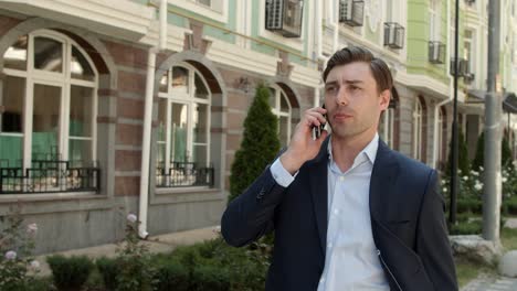 closeup businessman walking at beautiful street. man talking phone outside