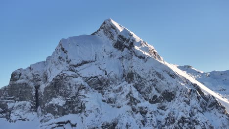 fronalpstock peak covered in snow under clear blue skies, kanton glarus, switzerland