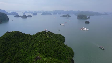 aerial of cruise ships traveling through ha long bay around limestone mountains in vietnam