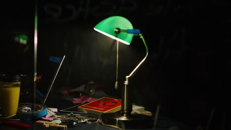 green desk lamp in a dark room