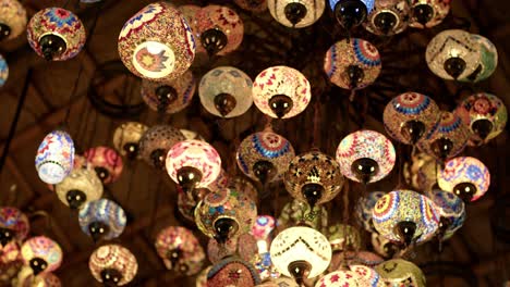 colorful turkish lamps hanging in a dubai market, glowing warmly with intricate designs