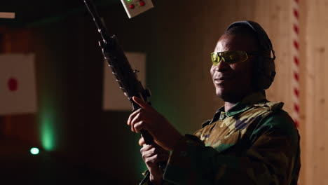 portrait of cheerful soldier doing training in shooting range, reloading rifle