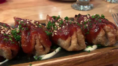 a shot of a delicious looking japanese gyoza dish on a wooden plate