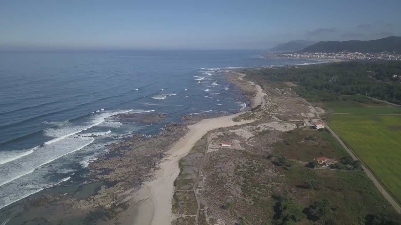 toma panorámica aérea de olas famosas con playa de arena y mar azul en el norte de portugal, caminha, vila praia de ancora