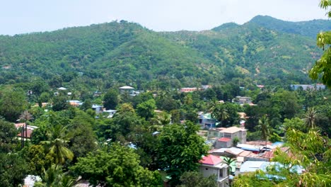 vista panorámica de las casas de la comunidad local ubicadas entre árboles verdes y colinas en la ciudad capital de dili, timor-leste, asia sureste