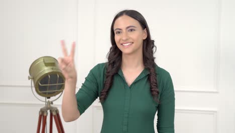 mujer india mostrando el signo de la victoria