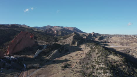 Aerial-flyover-past-towering-rock-ridgeline,-Garden-of-the-Gods,-Colorado