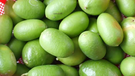 green lemon in a bowl on table,