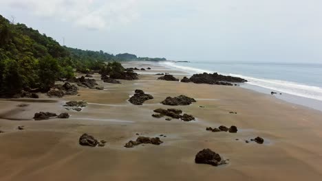 Drone-View-Flying-Over-Empty-Beach-During-Low-Tide-On-Cloudy-Day