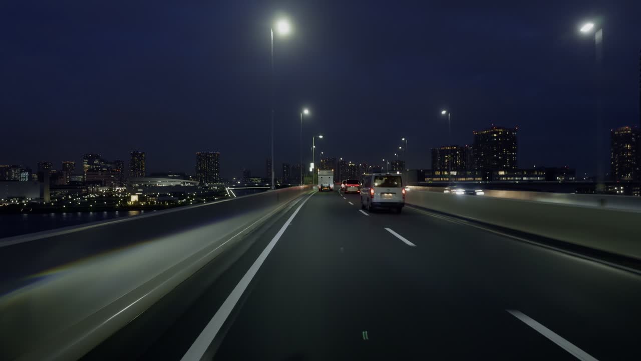 City Lights Ahead: Tokyo Highway at Night Witness Tokyo’s sprawling new territories on a nighttime drive, with bright highway lights leading the way