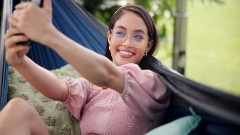 woman taking a selfie in a hammock