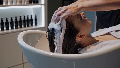 mujer lavándose el cabello en un salón