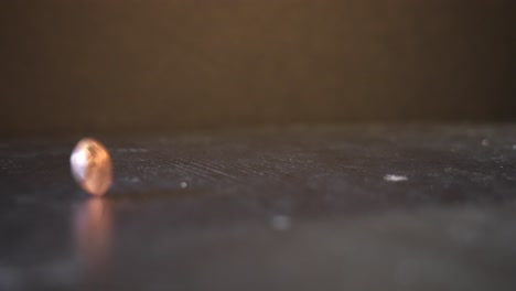 a new american penny spinning on a black table with black background