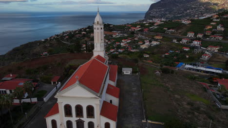 vista aérea de la iglesia de sao martinho en funchal, madeira: viajando a la hermosa iglesia durante la puesta de sol y con vistas a la ciudad y el océano