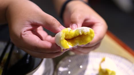 hands opening a delicious steamed bun