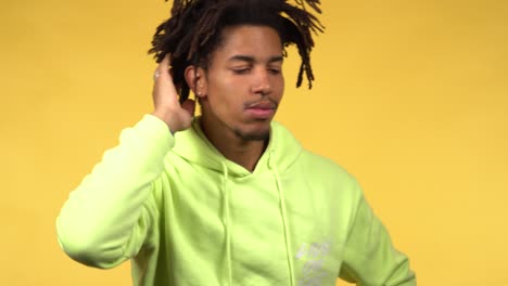 a thoughtful young black male student in a green hoodie deeply thinking
