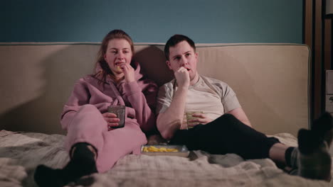 couple watching tv in bed