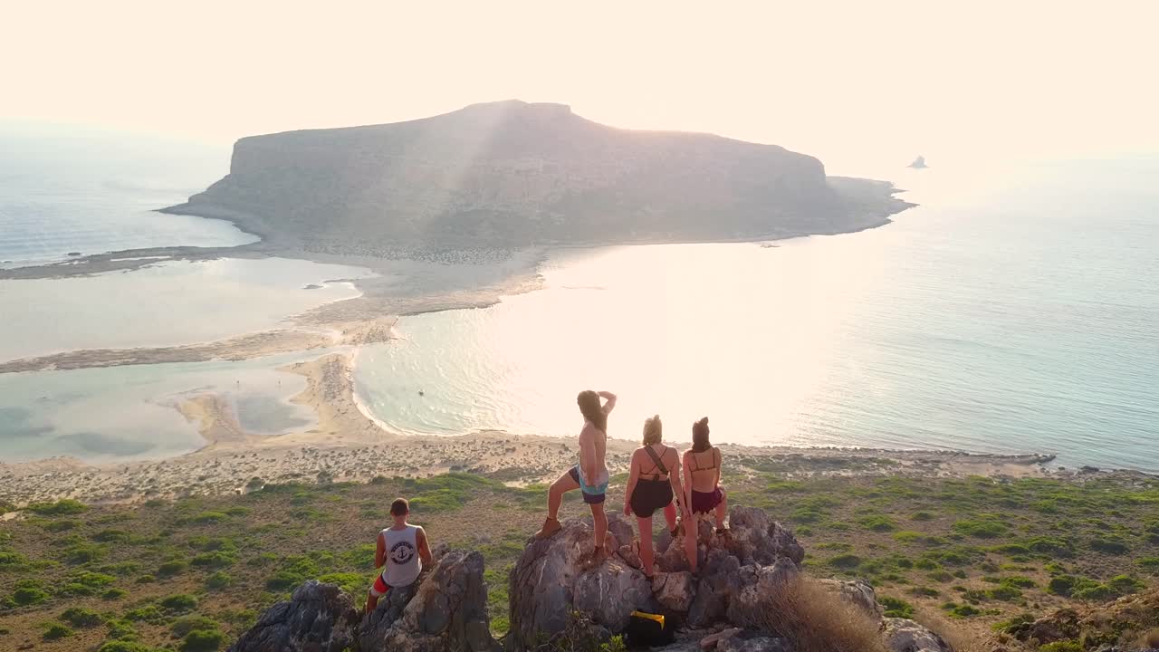 balos, crete - 무인 항공기 영상에서 바다를 드러내는 산 꼭대기에있는 여행자 그룹