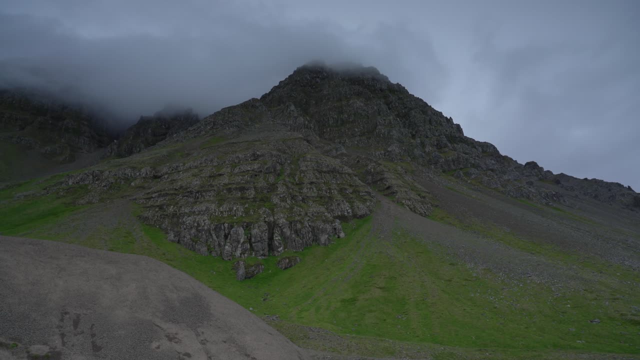 foto panorámica que muestra el paisaje montañoso con la carretera en strandir, westfjord durante un día nublado
