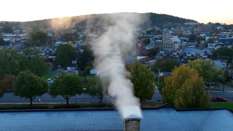 smoke coming out of chimney during sunrise in small town america