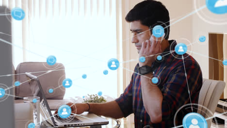 Animación-De-íconos-Conectados-Sobre-Un-Hombre-Asiático-Trabajando-Con-Una-Computadora-Portátil-Y-Hablando-Por-Teléfono-Celular
