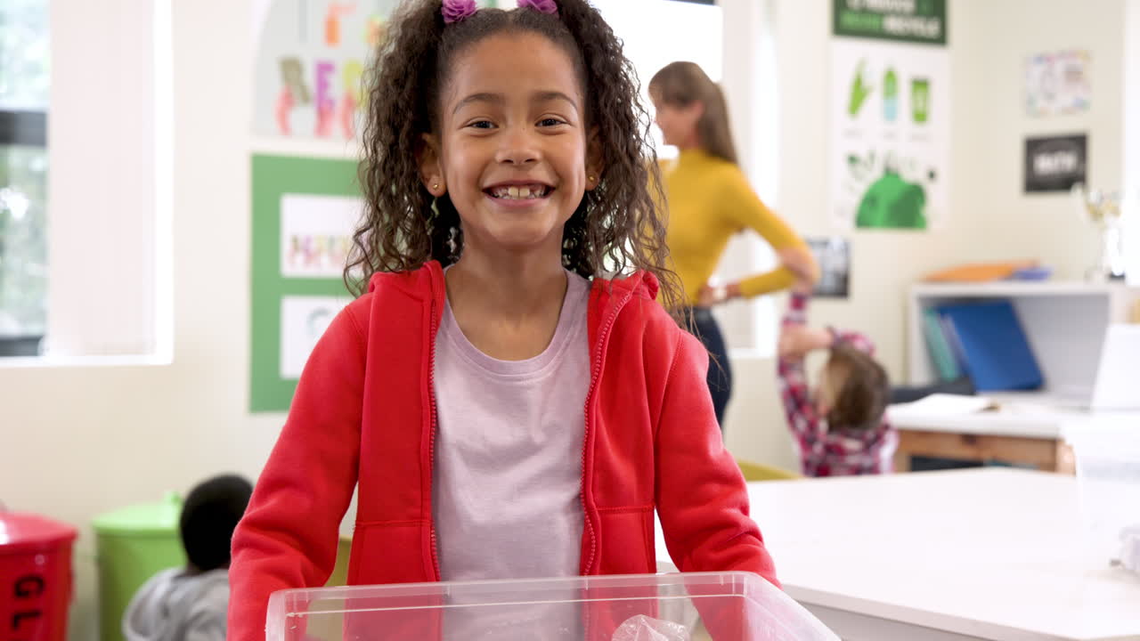 Smiling girl in red jacket enjoying classroom activities at school