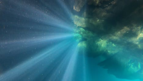 underwater rock with sun beams from water surface in mexico pacific's coast