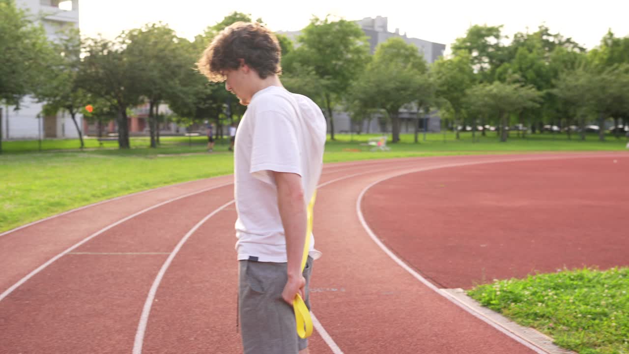 Man stretching with resistance band on track