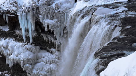 disparo a cámara lenta de un diluvio gigante de agua que fluye por una cascada helada en islandia