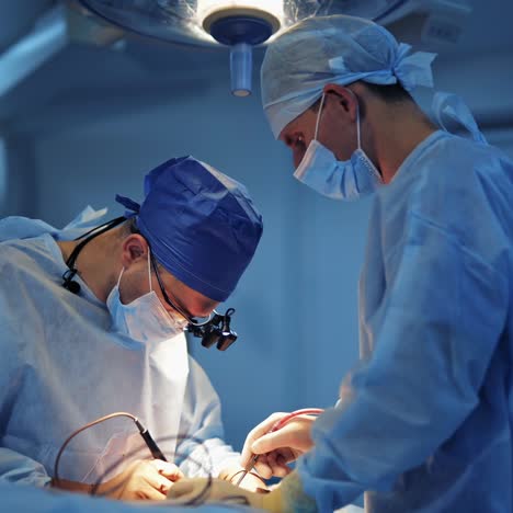 medical specialists in the modern operating room. two male surgeons work with neurosurgery instruments. doctors in scrubs