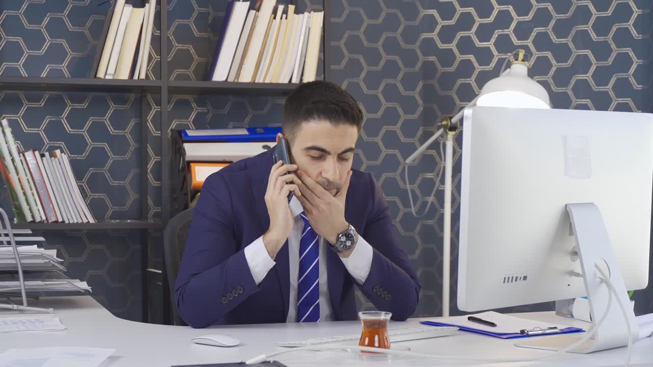 사무실 노동자 남자가 전화로 이야기하고 있습니다.