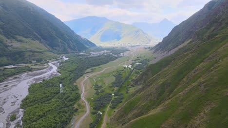 Drohnenaufnahme-Eines-Von-Bergen-Umgebenen-Flusstals