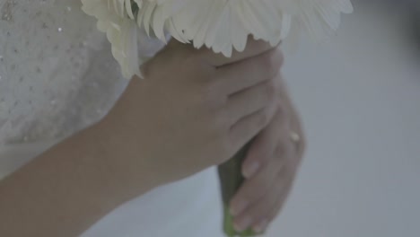 beautiful bride holding bouquet of daisies