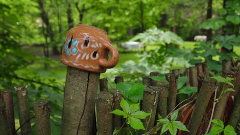 ornamental ceramic cup on wooden fence post