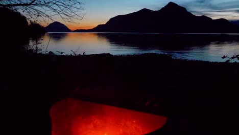 beautiful sunset revealed behind glowing oceanside campfire