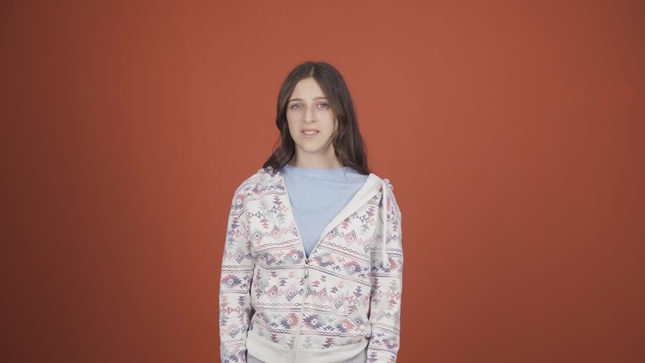 mujer joven haciendo una señal de alto para la cámara.