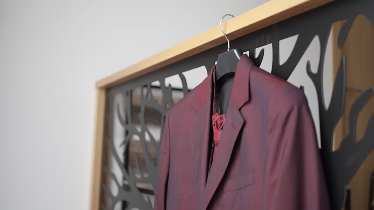 Elegant red suit displayed on a hanger against a modern decorative background