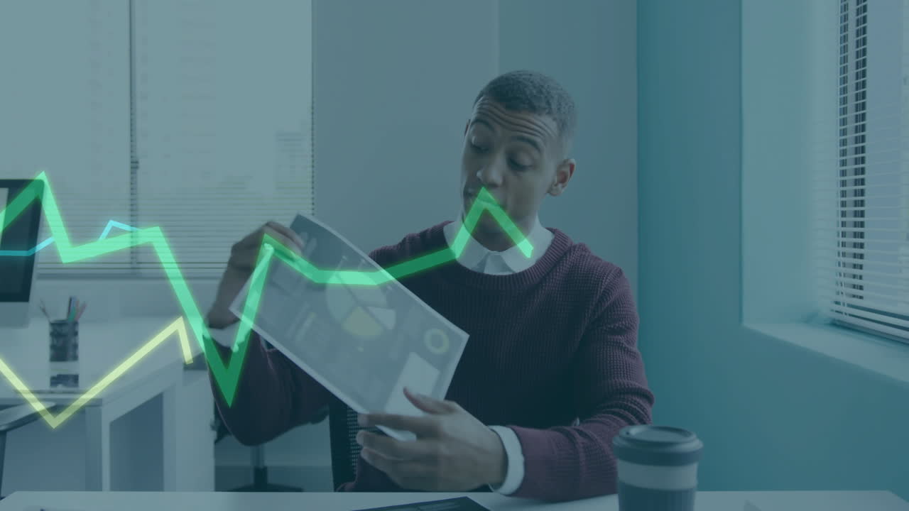 Businessman analyzing documents with financial graph animation overlay in office
