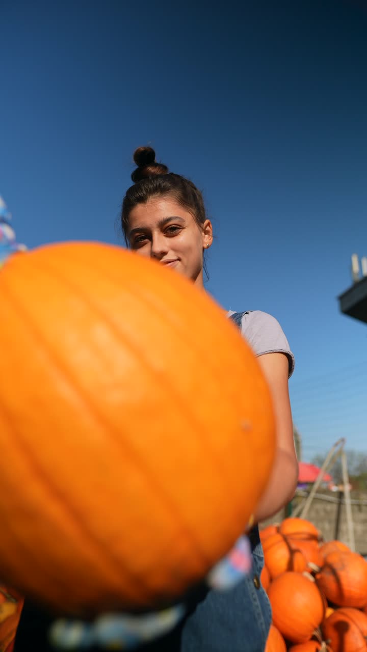 mujer sosteniendo una gran calabaza