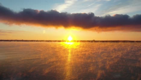 sunrise on lake shaped like a cross reveal