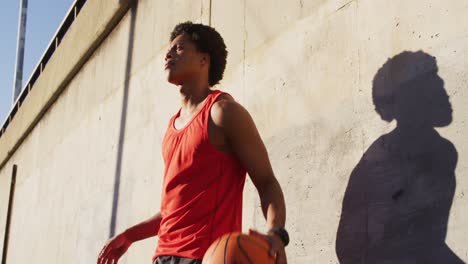 Fitter-Afroamerikanischer-Mann,-Der-Draußen-In-Der-Stadt-Trainiert-Und-Basketball-Hüpft