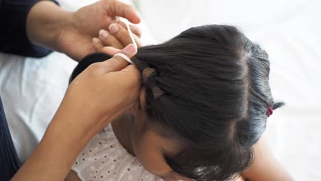 mother braiding daughter's hair